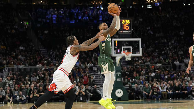 Chicago Bulls guard Coby White (0) shoots behind Chicago Bulls forward DeMar DeRozan (11) 